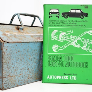 Può includere: Un manuale di officina verde per la Simca 1000 1961-70 Autobook di Kenneth Ball, pubblicato da Autopress LTD. La copertina presenta un disegno a linea di un'auto e di pezzi di motore.
