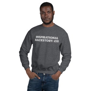 May include: A dark gray sweatshirt with white text that reads "Inspirational Backstory: £10".