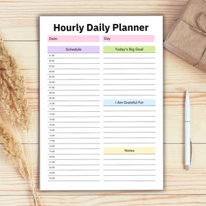 Puede incluir: Un planificador diario por hora imprimible con secciones para el horario, el gran objetivo del d&iacute;a, estoy agradecido por, y notas. El planificador tiene un fondo blanco con acentos rosa, verde, azul y amarillo.