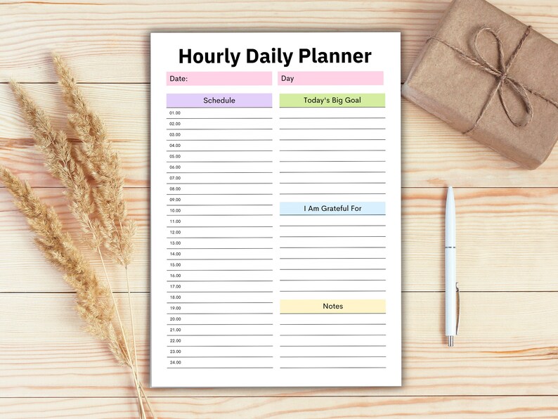 Puede incluir: Un planificador diario por hora imprimible con secciones para el horario, el gran objetivo del d&iacute;a, estoy agradecido por, y notas. El planificador tiene un fondo blanco con acentos rosa, verde, azul y amarillo.