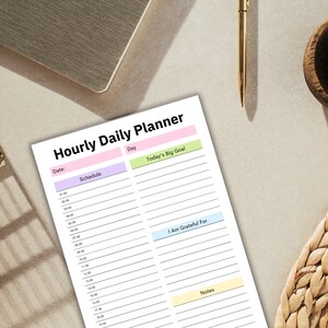 Puede incluir: Un planificador diario por horas imprimible con secciones para el horario, el d&iacute;a, el gran objetivo de hoy, estoy agradecido por, y notas. El planificador tiene un esquema de color rosa claro, verde claro y azul claro.
