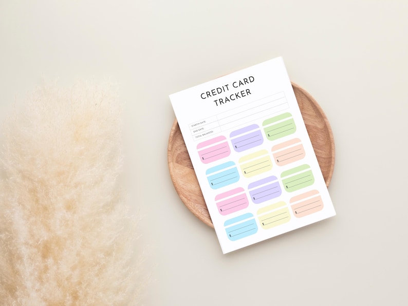 May include: A white sheet of paper with the words "CREDIT CARD TRACKER" printed at the top. The paper has spaces for tracking credit card information and colorful credit card-shaped boxes.