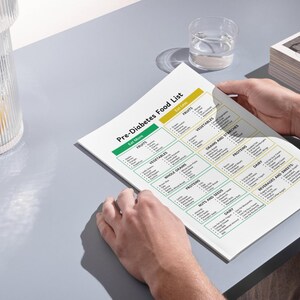 May include: A white sheet of paper with a green and yellow chart titled "Pre-Diabetes Food List". The chart lists foods to eat more of and foods to eat less of, categorized by food groups such as fruits, vegetables, whole grains, and proteins.