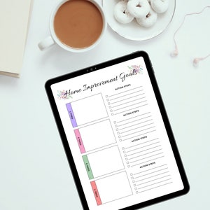 May include: A digital tablet with a checklist for home improvement goals. The checklist has four sections for goals and action steps. The tablet is on a white surface with a cup of coffee and a plate of donuts.