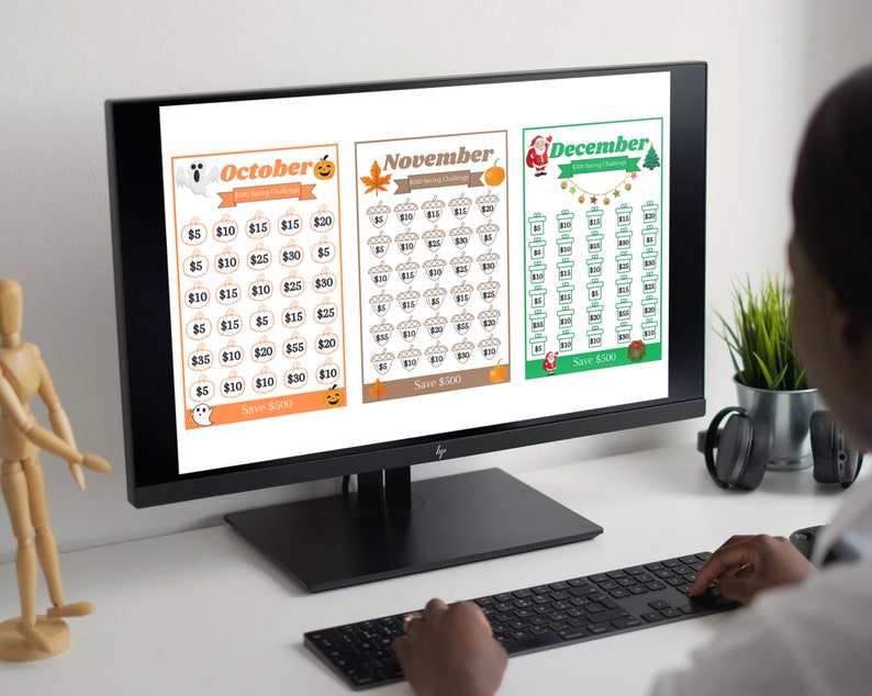 May include: A computer screen displaying three printable savings challenge calendars for October, November, and December. Each calendar features a different holiday theme with corresponding icons and a total savings goal of $500.