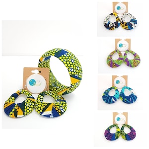 May include: A set of colourful African print earrings and a matching bracelet. The earrings are oval shaped and the bracelet is a wide band. The fabric is a vibrant yellow, blue, and green pattern.
