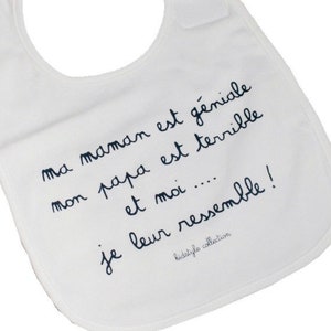 May include: White baby bib with black text that reads "ma maman est g&eacute;niale mon papa est terrible et moi.... je leur ressemble!" and "kidstyle collection".