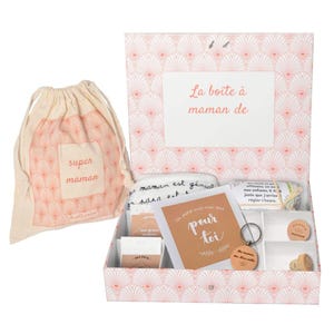 May include: A pink and white gift box with a white fabric bag that says "super maman" on it. The box is open and contains a white cloth with black writing, a card that says "Un petit mot rien que pour toi", a key chain, and a small wooden box with a cork stopper.