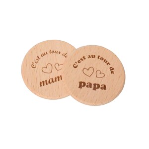 May include: Two round wooden coasters with the text "C'est au tour de" and two hearts above the words "mam" and "papa".