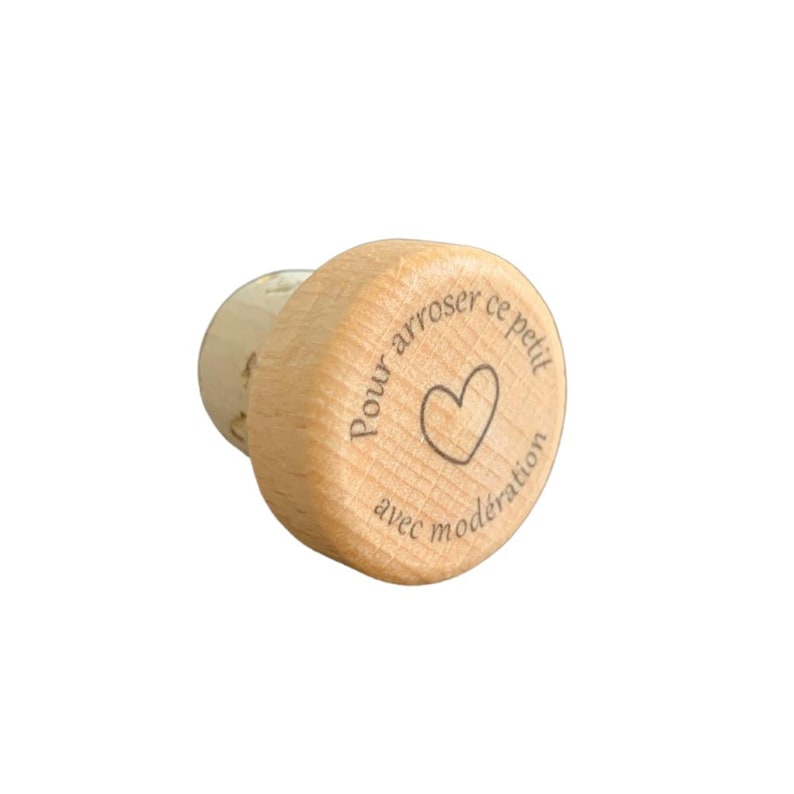 May include: A wooden bottle stopper with the text "Pour arroser ce petit avec moderation" and a heart symbol.