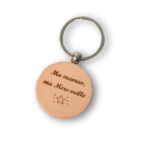May include: Wooden keychain with a round, light brown tag that says "Ma maman, ma M&egrave;re-veille" with a small star graphic.