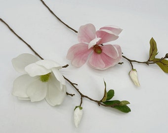 Puede incluir: Dos tallos de flores de magnolia artificiales con ramas marrones. Un tallo tiene una flor de magnolia blanca y un capullo blanco. El otro tallo tiene una flor de magnolia rosa y un capullo blanco.