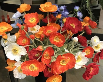 May include: A bouquet of artificial poppies in various shades of red, orange, and white. The flowers are arranged in a vase and have a realistic appearance.