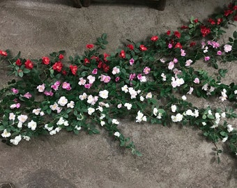 Puede incluir: Una larga guirnalda de flores artificiales con hojas verdes y flores rosas, blancas y rojas. La guirnalda es perfecta para añadir un toque de naturaleza a cualquier espacio.