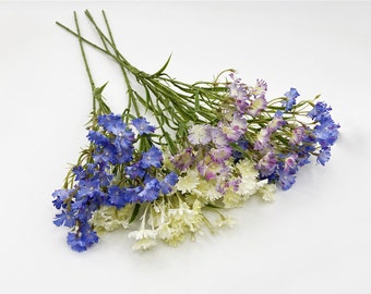 May include: A bouquet of artificial flowers with blue, white, and purple blooms. The flowers have a delicate, feathery appearance and are arranged in a cluster.