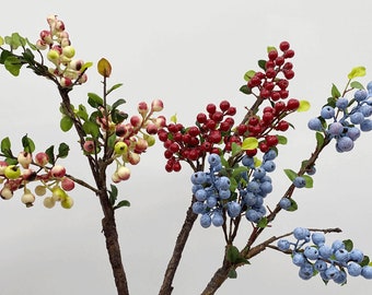 May include: Four sprigs of artificial berry branches with different colored berries. The branches have brown stems and green leaves. The berries are white with pink highlights, red, blue, and light blue.