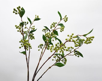 May include: A bunch of artificial green berry sprigs with small green leaves. The sprigs are arranged in a bouquet.