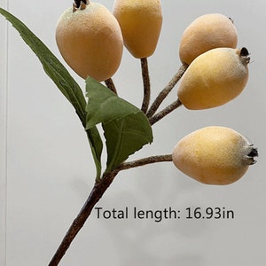 May include: A branch with five yellow felt fruit and green leaves. The branch is brown and has a total length of 16.93 inches.