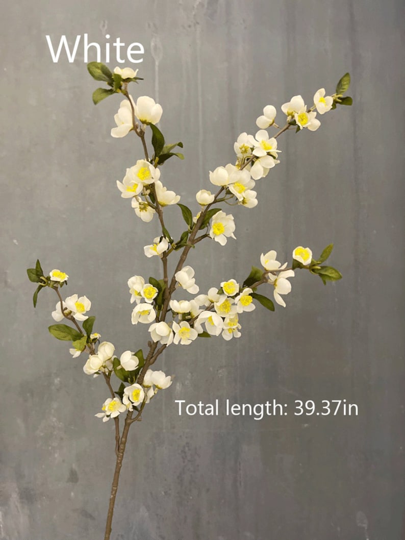 May include: White artificial flower branch with small white blossoms and green leaves. The branch is 39.37 inches long.