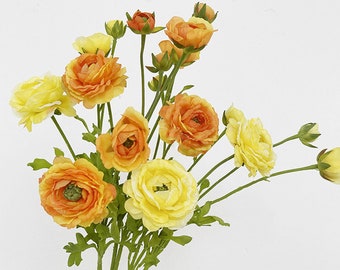 May include: A bouquet of artificial flowers with yellow and orange blooms. The flowers have a delicate, layered appearance and are arranged in a cluster.