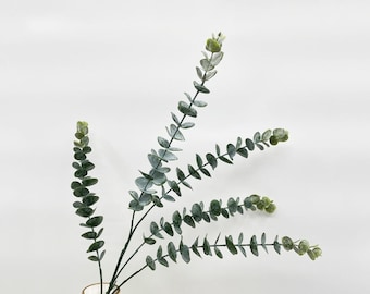 May include: A bunch of artificial eucalyptus sprigs with green leaves. The leaves are arranged in a natural, flowing pattern.