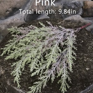 Puede incluir: Rama de vegetaci&oacute;n artificial rosa con una longitud total de 25 cm. La rama est&aacute; hecha de pl&aacute;stico y tiene un aspecto realista.
