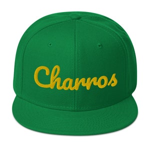 May include: A green and gold baseball cap with the word "Chanros" embroidered on the front.