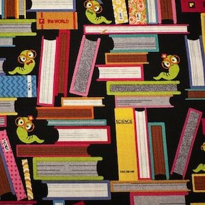 May include: A black fabric with a repeating pattern of colorful books stacked on top of each other. Each book has a different title, such as "The World", "Science", and "Music". There are also small green worms with glasses and graduation caps on top of the books.