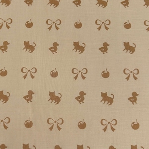 May include: A beige fabric with a repeating pattern of brown ducks, cats, bows, and apples.