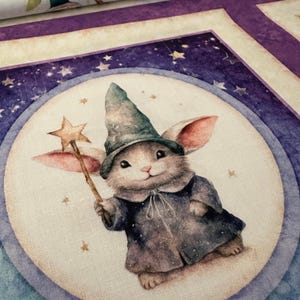 May include: A whimsical fabric design featuring a bunny dressed as a wizard, holding a star wand. The bunny is set against a moon and starry background, with a color palette of blues, purples, and creams. The fabric has a repeating pattern.
