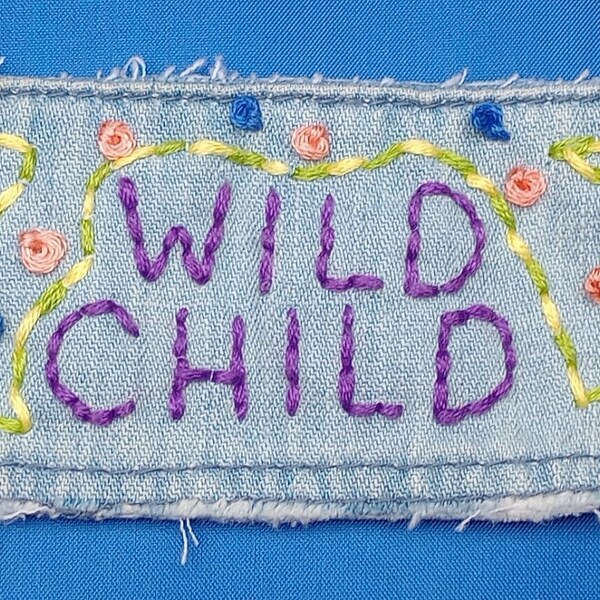 Unique upcycled hand embroidered denim wristband cuff bracelet with slogan 'Wild Child'