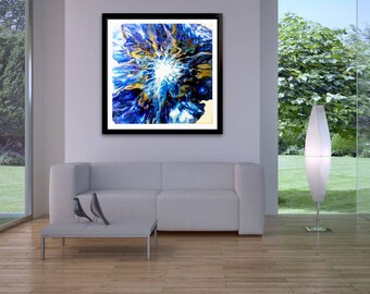 May include: Abstract art print in a black frame. The artwork features a vibrant, swirling design with shades of blue, gold, and white, creating a dynamic and eye-catching composition. The painting is displayed in a modern living room setting.