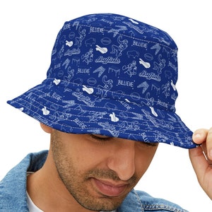 May include: A blue bucket hat with a white pattern of the words "Buffalo Bills" and "Believe" repeated throughout the hat.
