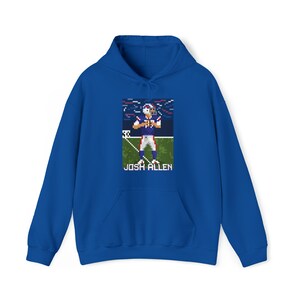 K&ouml;nnte beinhalten: Ein k&ouml;nigsblauer Hoodie mit einem Pixelbild eines Footballspielers in einem blau-roten Trikot. Der Text "JOSH ALLEN" ist unter dem Bild gedruckt.