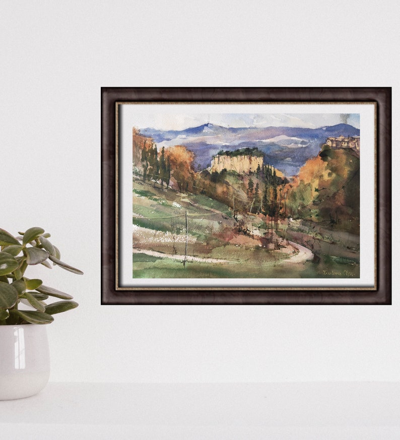 K&ouml;nnte beinhalten: Ein Aquarellbild einer kurvigen Stra&szlig;e, die durch ein &uuml;ppiges gr&uuml;nes Tal f&uuml;hrt, mit einer Bergkette im Hintergrund. Das Bild zeigt eine Mischung aus gr&uuml;nen, braunen und blauen Farbt&ouml;nen, mit einem Hauch von Gelb und Orange f&uuml;r das Herbstlaub.