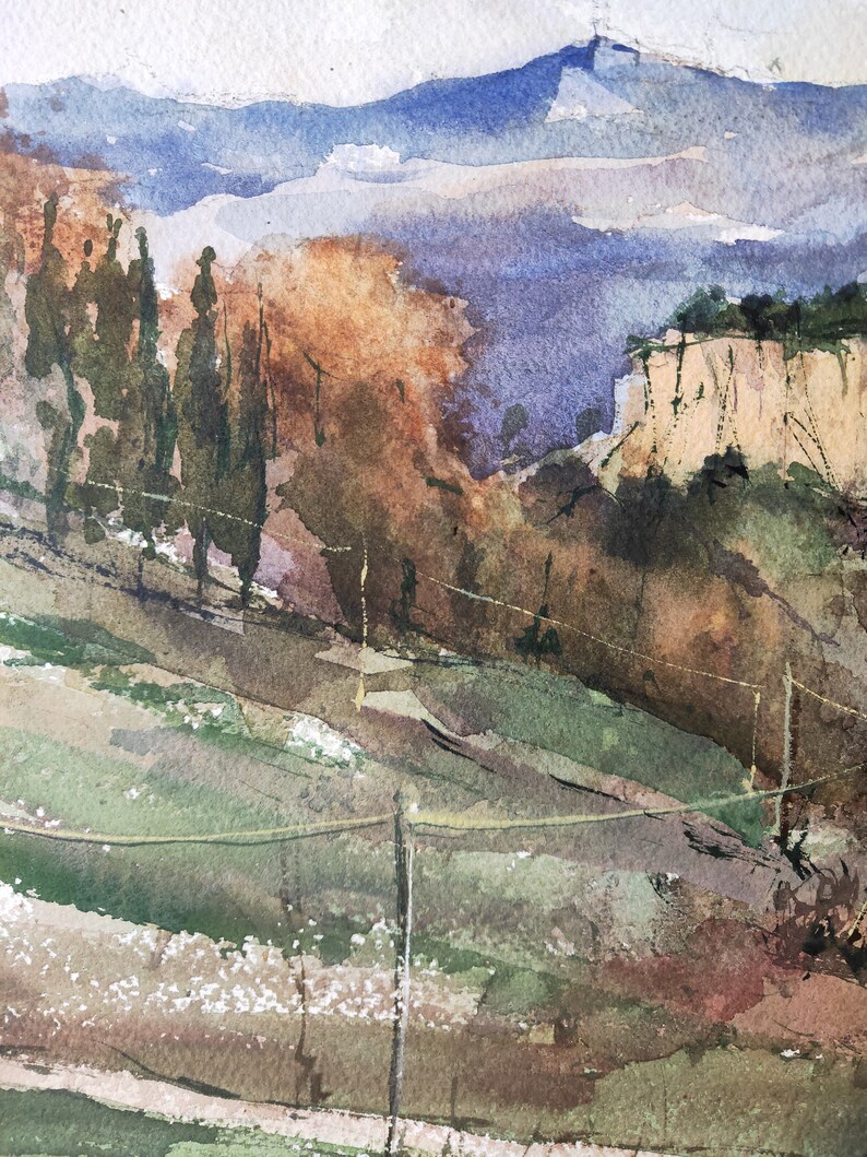 K&ouml;nnte beinhalten: Aquarellmalerei einer Landschaft mit einem Gebirge im Hintergrund, einer Felswand im Mittelgrund und einem Feld mit gr&uuml;nem Gras im Vordergrund. Das Gem&auml;lde ist in Blaut&ouml;nen, Gr&uuml;n, Braun und Wei&szlig; gehalten.