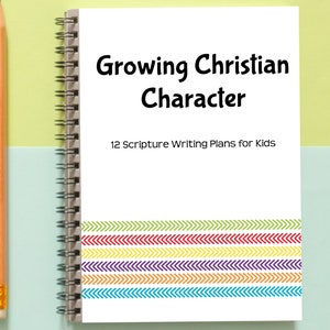 May include: A white notebook with a spiral binding. The cover has the text "Growing Christian Character" and "12 Scripture Writing Plans for Kids". The bottom of the cover has a colorful design of chevron stripes.