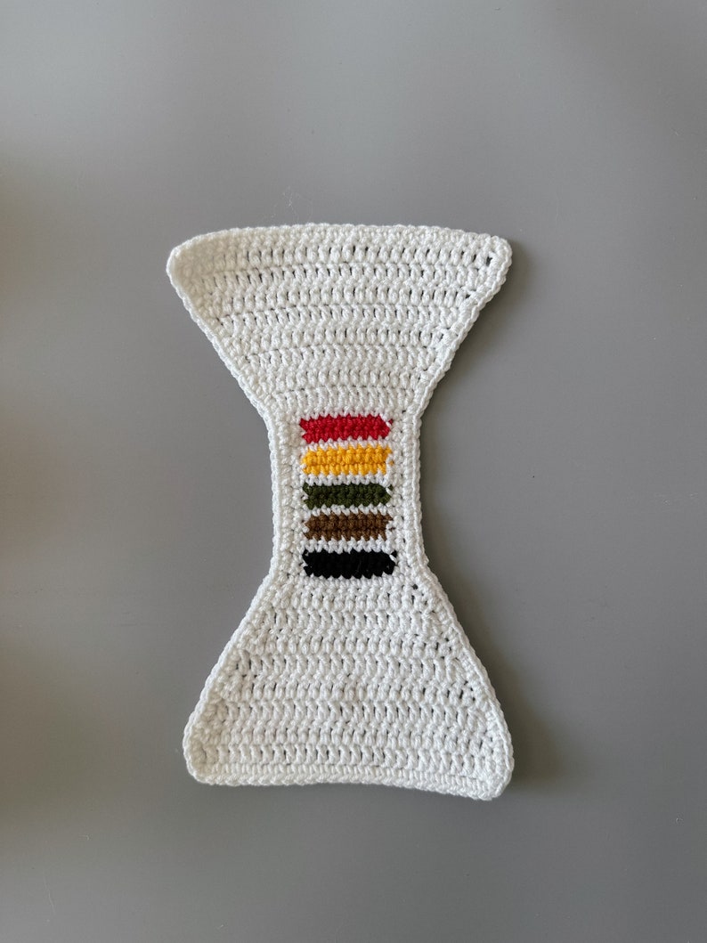 May include: White crocheted diaper cover with a colorful stripe design in red, yellow, green, brown, and black.