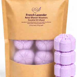 May include: A brown paper pouch containing light purple flower-shaped shower steamers. The label reads French Lavender Relax Shower Steamers, Essential Oil Infused, with ingredients and 2.5 oz. each listed. Four steamers are stacked vertically.