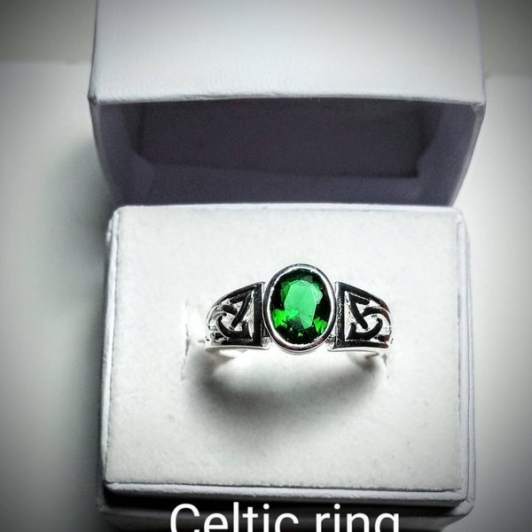 Celtic Emerald Green Stone Ring. Oval faceted 8 × 6 mm in Sterling Silver with a Celtic Trinity knot shoulder. Sizes 7, 8, 9, and 10.