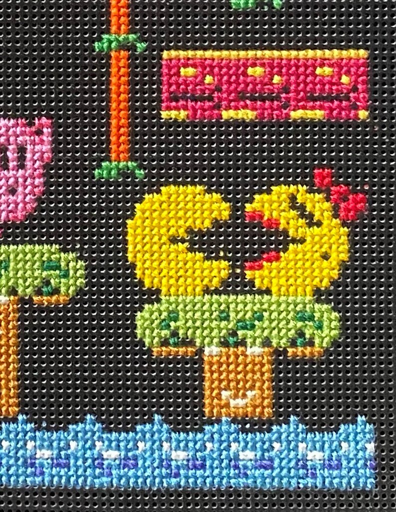 Puede incluir: Un personaje amarillo Pac-Man con una boca roja y un tronco de &aacute;rbol verde y marr&oacute;n. El personaje est&aacute; en una plataforma verde con una flor roja en la parte superior. El fondo es negro con un patr&oacute;n de onda azul y blanco en la parte inferior.