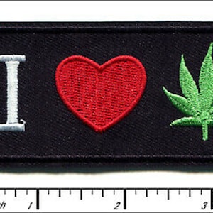 May include: A black embroidered patch with the text "I love" in white, a red heart, and a green marijuana leaf.