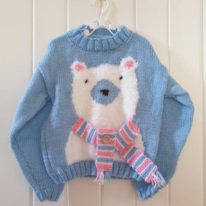 Fluffy polar bear jumper with cute scarf detail.