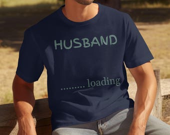May include: A navy blue t-shirt with the text "HUSBAND...loading" in light blue.