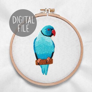 Op de afbeelding: Geborduurde blauwe papegaai op een bruine tak, in een houten borduurring. De papegaai heeft een rode snavel en oog, met de tekst "DIGITAL FILE" in een grijze cirkel.
