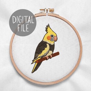 May include: A digital file of a cross-stitch design featuring a yellow, gray, and black cockatiel perched on a brown branch. The bird is inside a wooden embroidery hoop. The text "DIGITAL FILE" is in a gray circle.