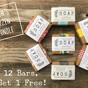 May include: A baker's dozen bundle of handmade soap bars with various scents, including orange & clove, sandalwood & love, peppermint poppy seed, lemon eucalyptus, honey almond oatmeal, and activated charcoal. The soap bars are wrapped in brown paper with decorative paper and ribbon accents. The text "BAKER'S DOZEN BUNDLE" is displayed in a white box at the top of the image. The text "Buy 12 Bars, Get 1 Free!" is displayed at the bottom of the image.