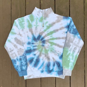 May include: A blue, green, and gray tie-dye sweatshirt with a quarter-zip closure.