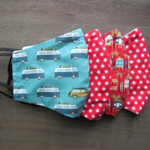 May include: Four face masks with elastic ear loops. One mask is teal with a pattern of blue and white surf vans. Two masks are red with white polka dots. The fourth mask is red with a beach scene.