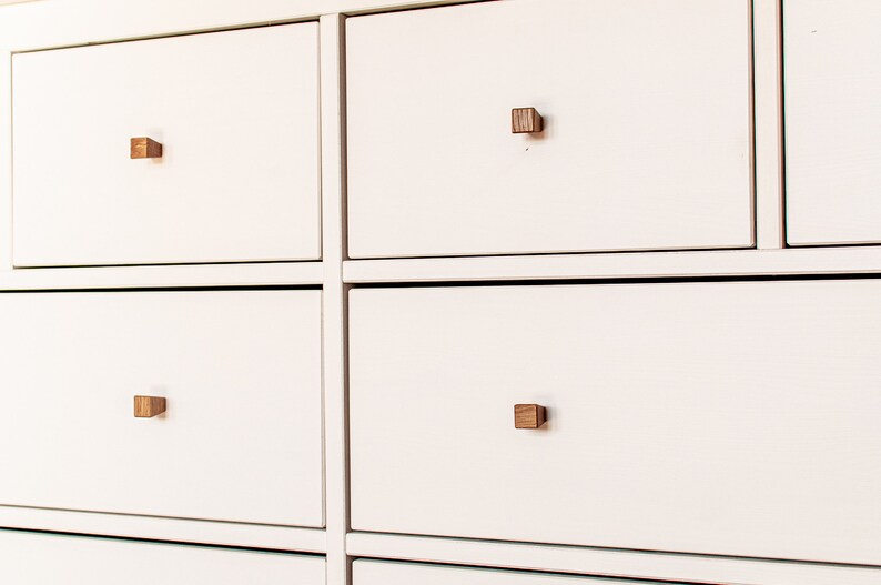 May include: White chest of drawers with six drawers and wooden square knobs.